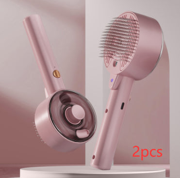 Pink handheld hair dryer with brush attachment on a light pink background