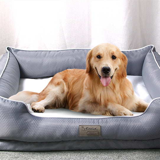 Dog lying on a gray pet bed with a visible brand logo.